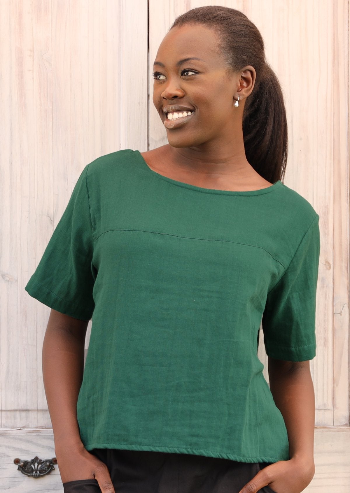 Model wears deep green cotton gauze T-shirt style top