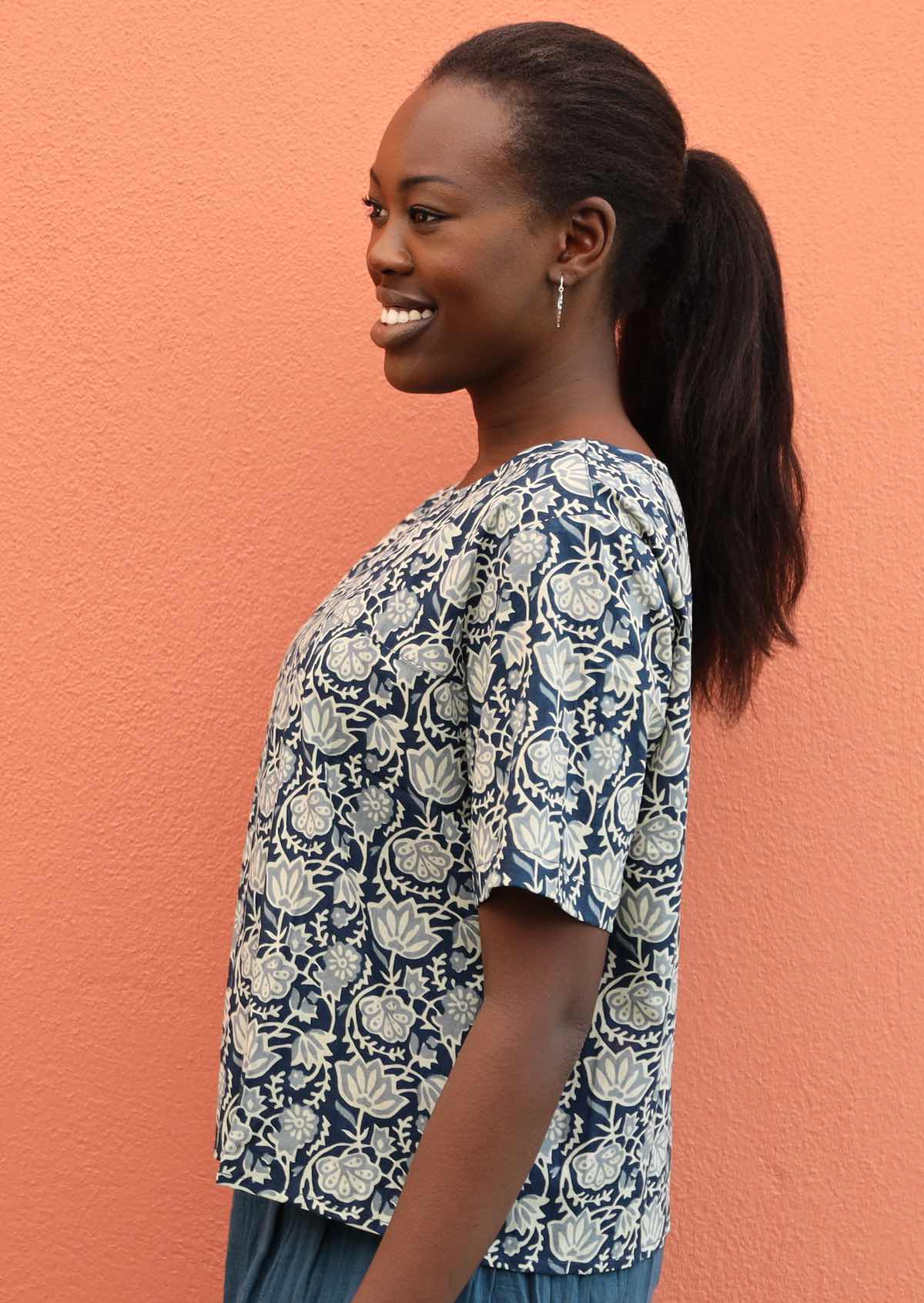 Model wears a short sleeve top with blue and white florals. 