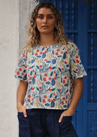 Model wears a short sleeve cotton top with a round neckline. 
