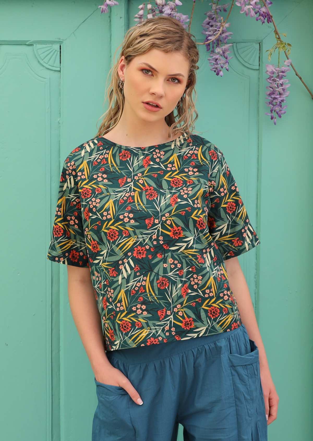 Model wears top with a round neckline and short sleeves. 