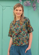 Model wears 100% cotton top with a green floral pattern. 