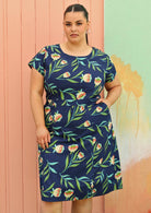 Plus size model wearing flattering cotton dress in navy blue with cap sleeves & pockets