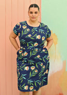 Plus size model wearing flattering cotton dress in navy blue  with pockets
