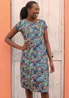 Happy model wears a dress with cap sleeves and a round neckline. 