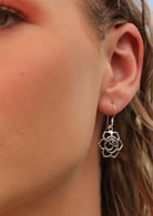 model wearing large silver om and flower design dangly earring 