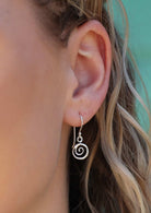 woman wearing small silver spiral dangly earring