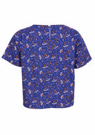 Pia top is made of 100% cotton and features a button at the nape of the neck. 