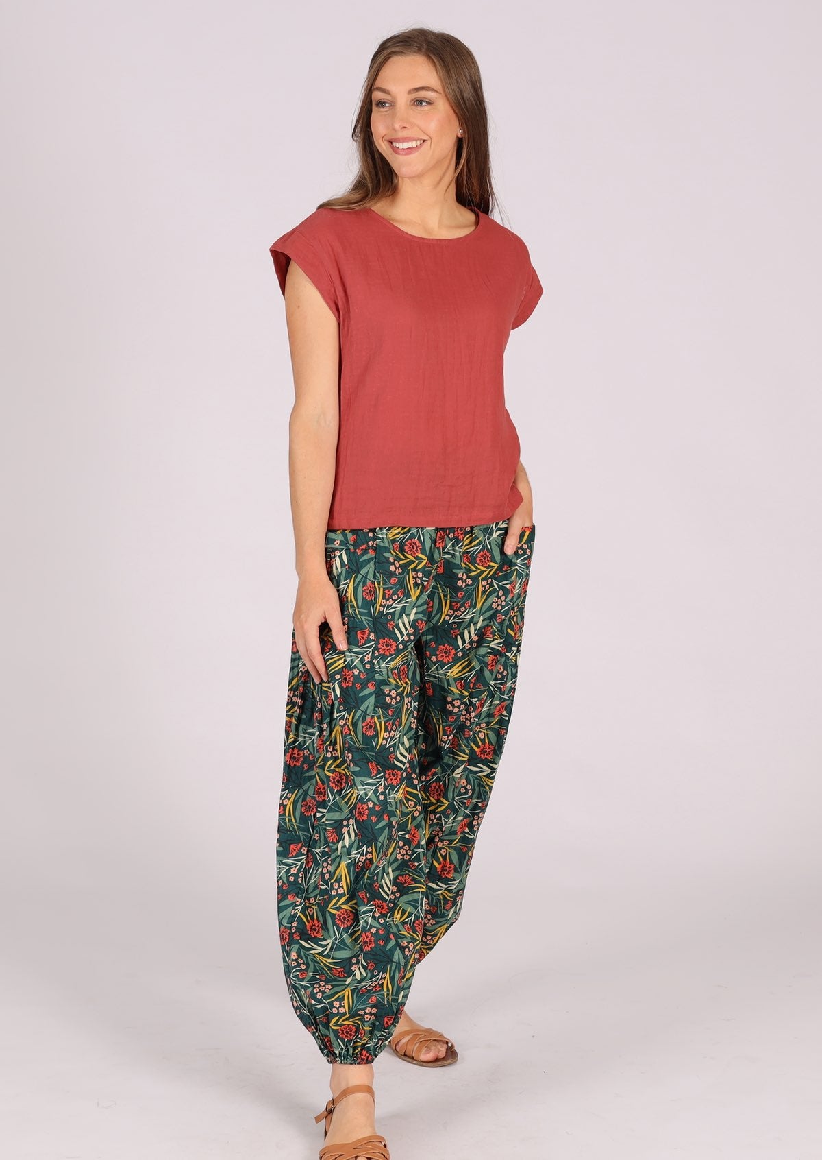 Woman wearing green cotton floral harem pants with pink top