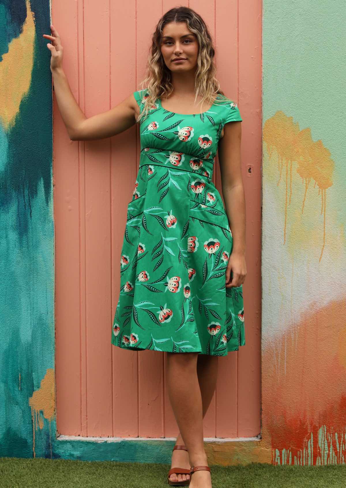 Model wears floral print green dress. 