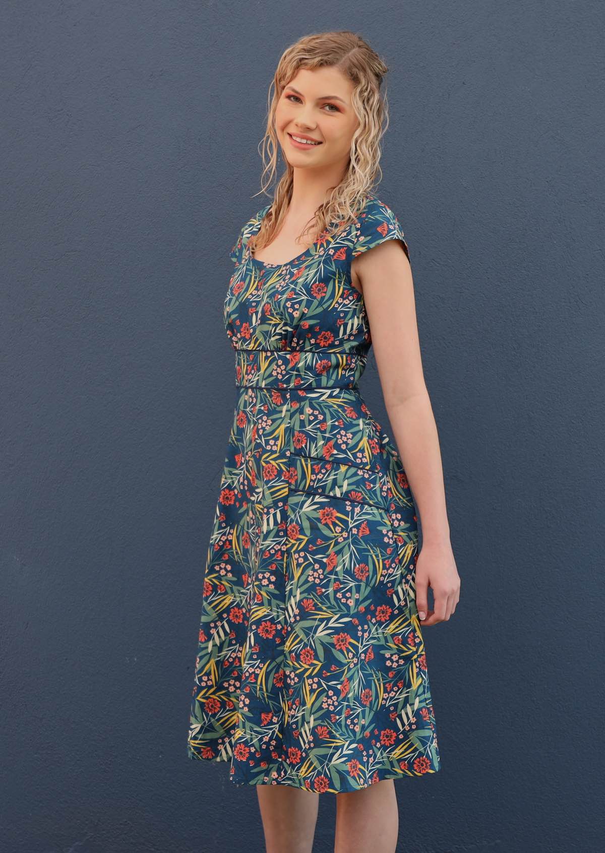 Model wears dress with cap sleeves and pockets. 