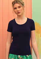 Woman wearing a scoop neck navy blue rayon fitted t-shirt.