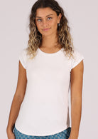Woman wearing a soft flattering fit white rayon jersey t-shirt with blue pants.
