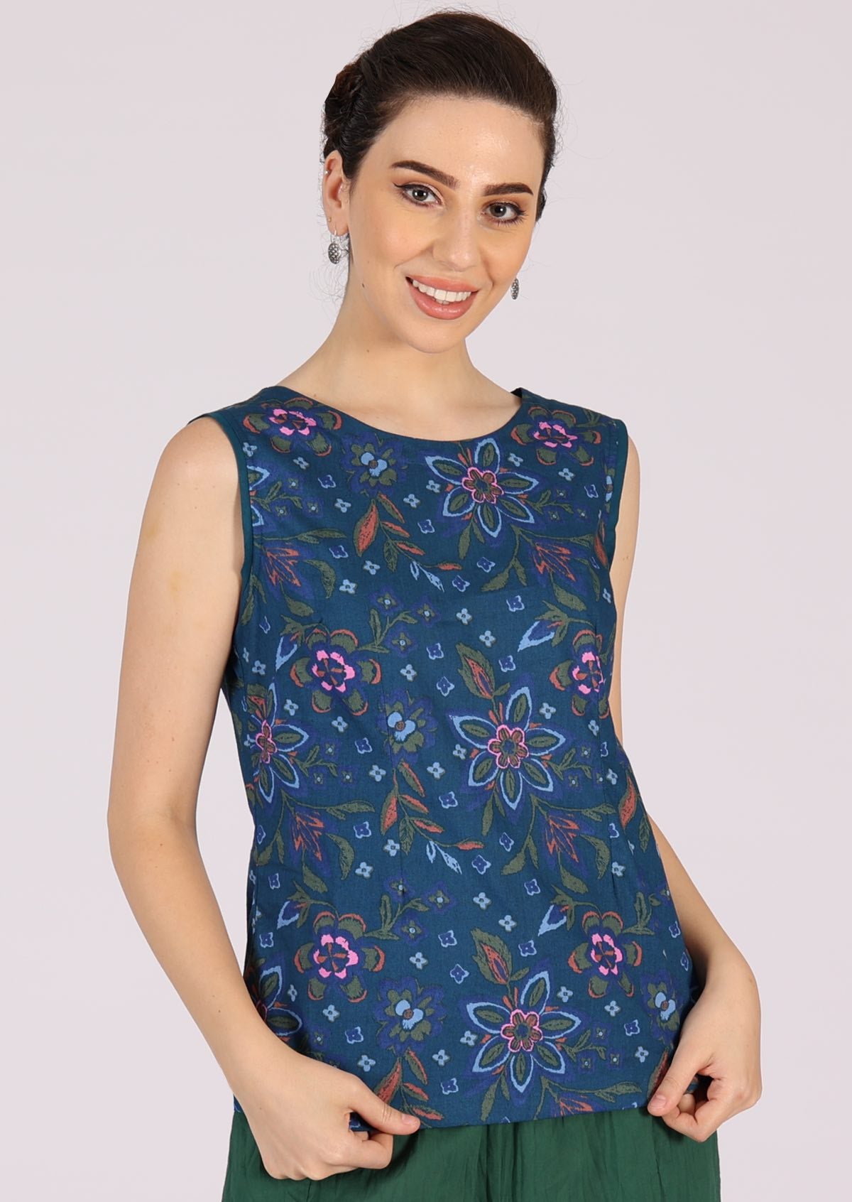 Model wears sleeveless cotton top with a blue plain trim around the arms to complement the blue base. 