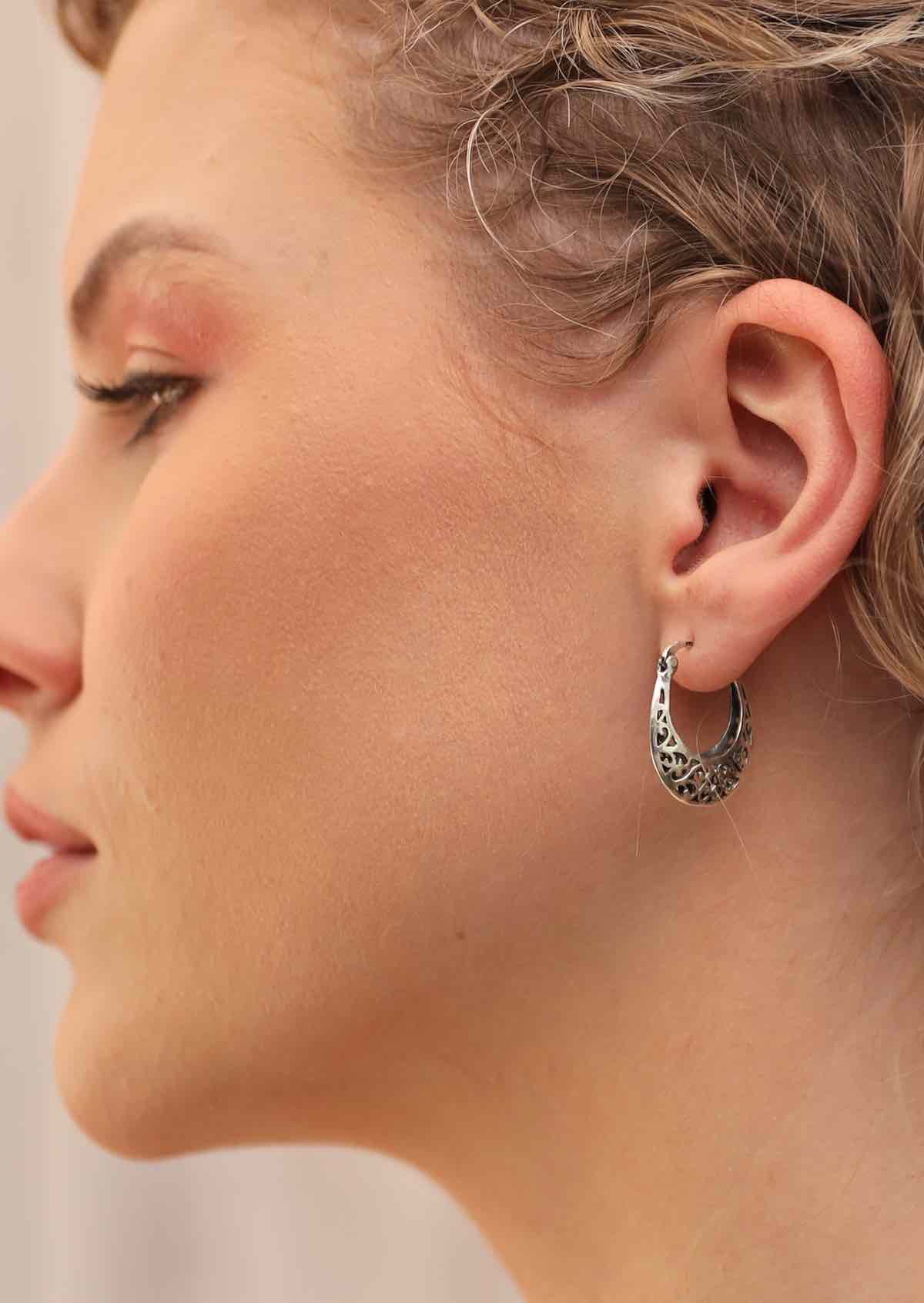 silver hoop earrings on woman's ear