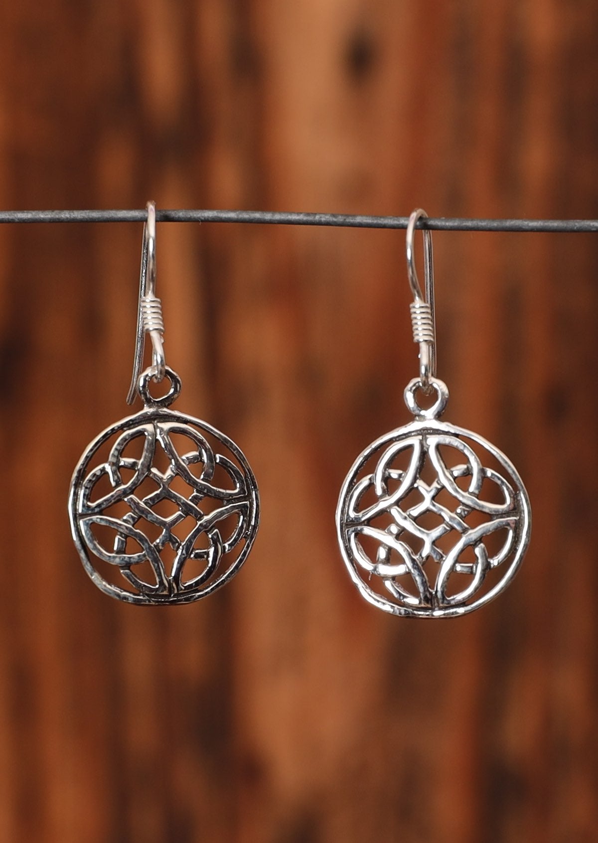 92.5% silver circular Celtic style earrings on a wire for display.