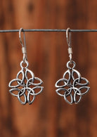 92.5% silver Celtic clover earrings sit on a wire for display.