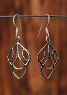 92.5% silver deco leaf style earrings sit on a wire for display.