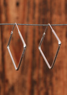 92.5% silver square diamond shaped earrings on a wire for display.