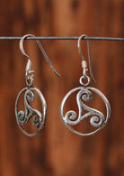 92.5% silver Triskele earrings in a circle hanging on a wire for display.