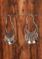 92.5% silver gypsy style earrings with stars hanging from them sit on a wire for display.