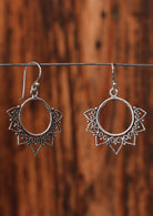 92.5% silver boho style earrings with heart petals sitting on a wire for display.