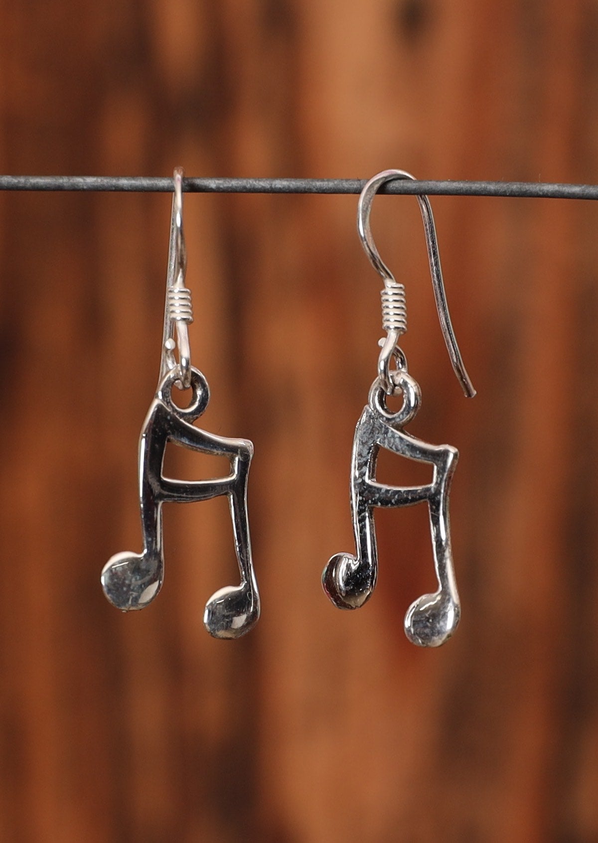 92.5% silver musical note earrings on a wire for display.