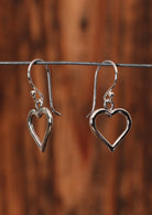 92.5% Silver heart shaped earrings on a wire for display.