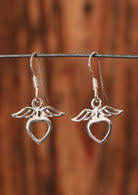 92.5% silver heart earrings with wings on a wire for display.