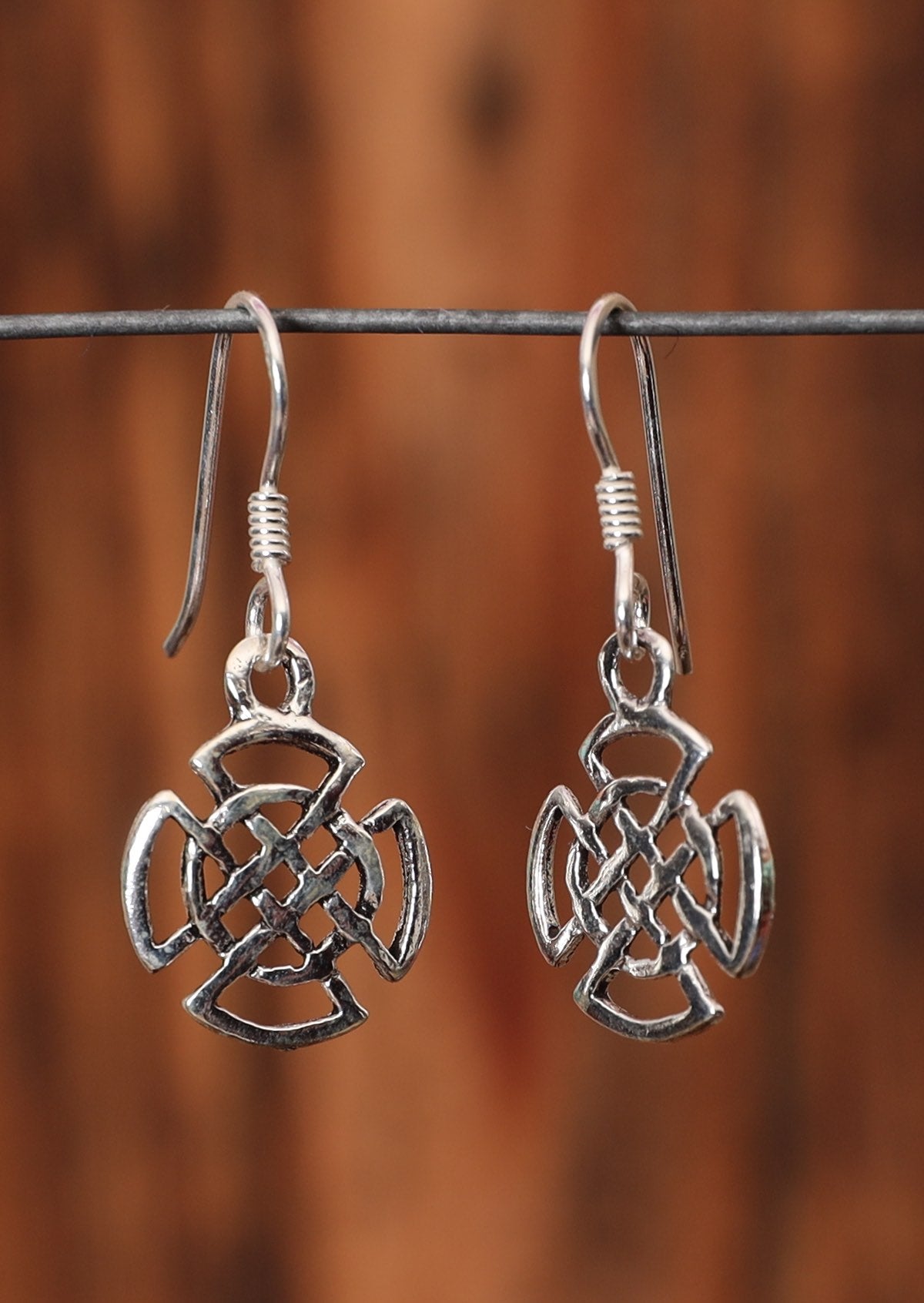 92.5% silver Celtic style woven shield earrings on a wire for display.
