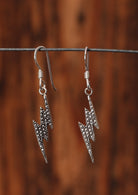 92.5% silver lightning bolt earrings on a wire for display.