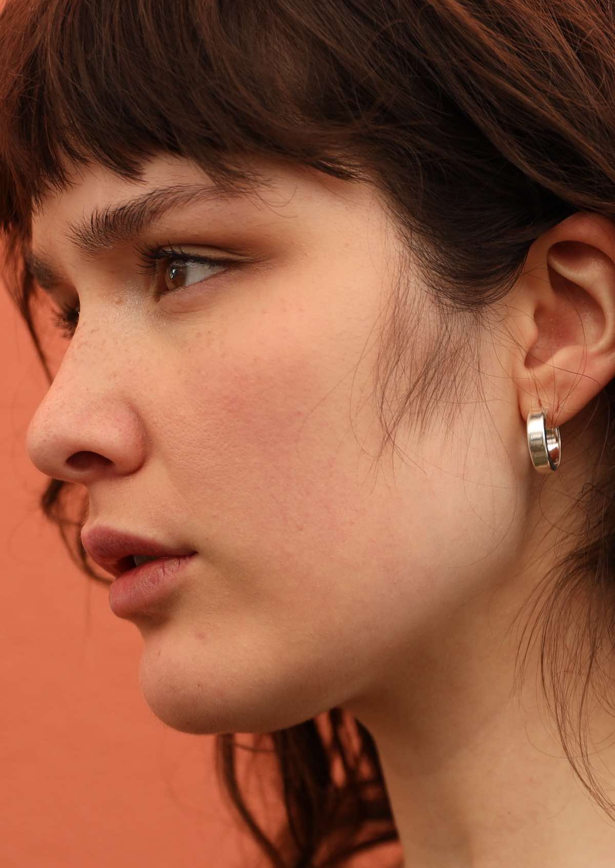 92.5% silver small thick hoop earrings on model with dark hair