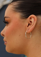 slender silver hoop earring on woman with dark hair