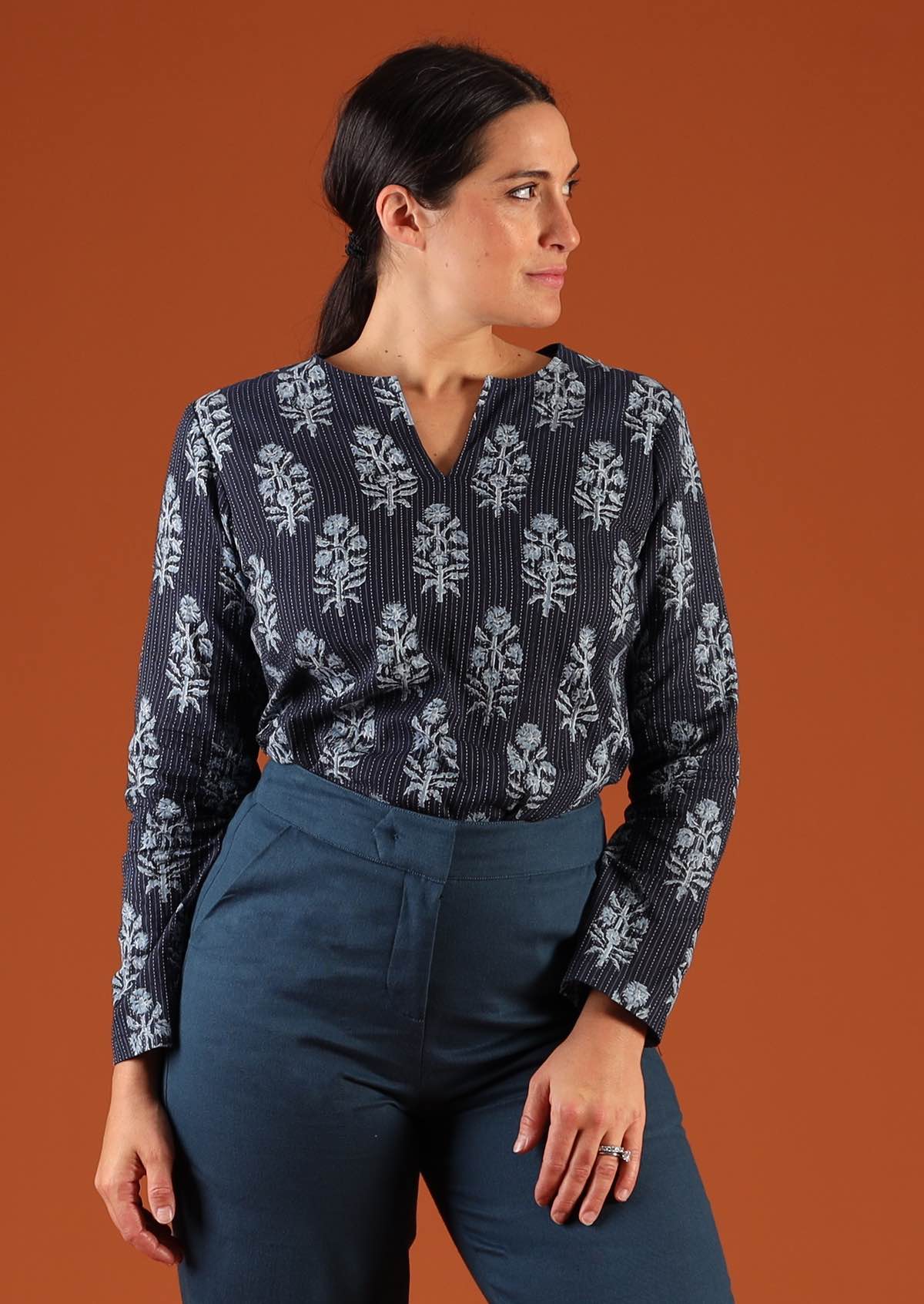 Model wearing Sophia Blouse Navy Blue cotton Indian print  tucked into teal cotton pants