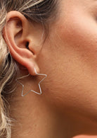 woman wearing silver star hoop earrings 