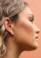 woman wearing silver star shaped earrings 