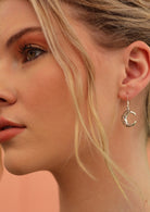 Model wears sterling silver celtic crescent moon earrings on hook