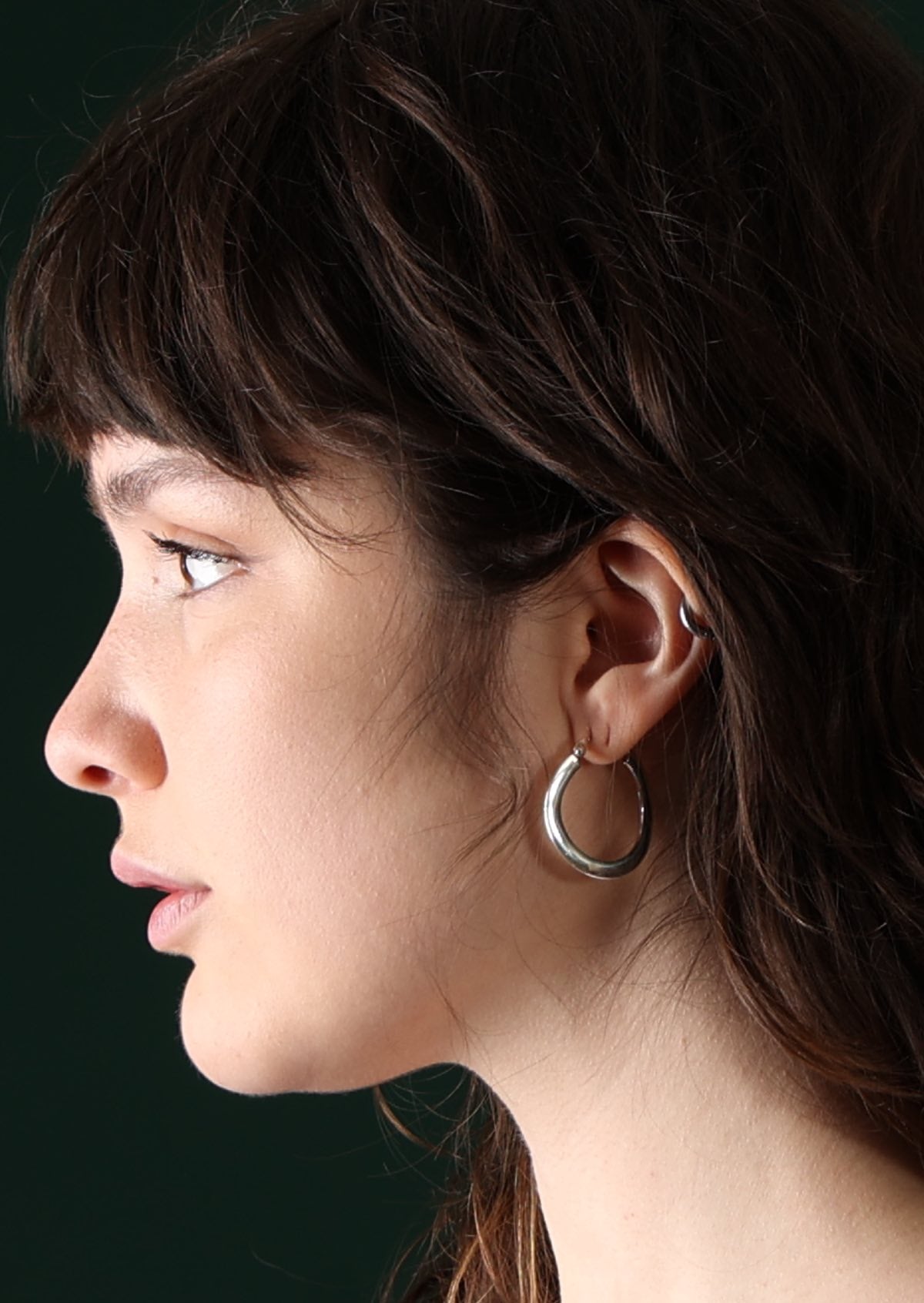 Model wearing large silver hoop earring
