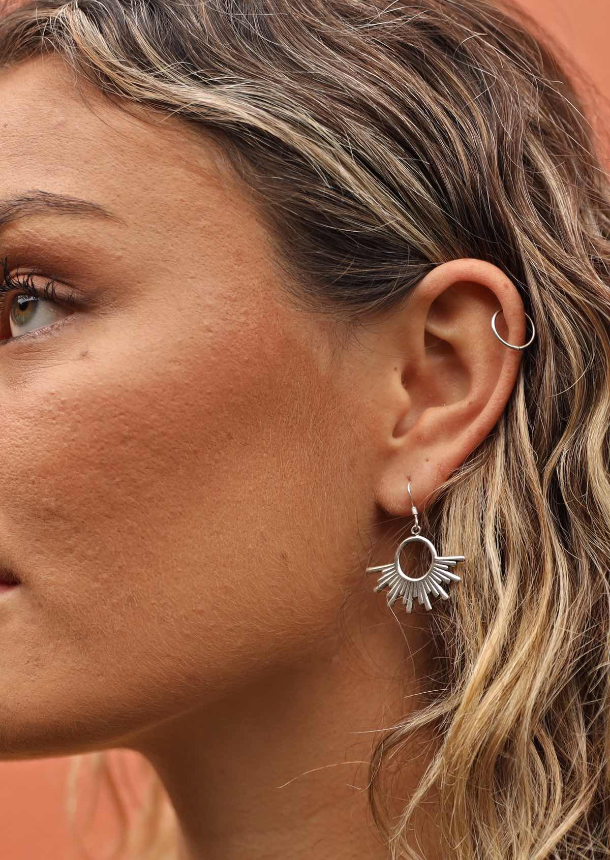 woman wearing sun inspired boho silver earring