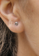 Simple small sterling silver studs with a  swirl design imprinted on the front