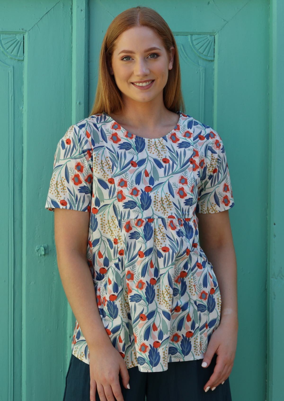 Model wears cotton floral top with pin tucks in front and pockets