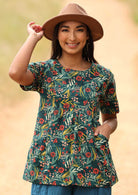 Model styles loose fitting cotton top with pants and a hat. 