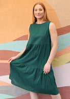 Model with orange hair wears loose fitting three tiered dress. 