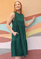 Woman wears a double cotton green dress with a round neckline. 