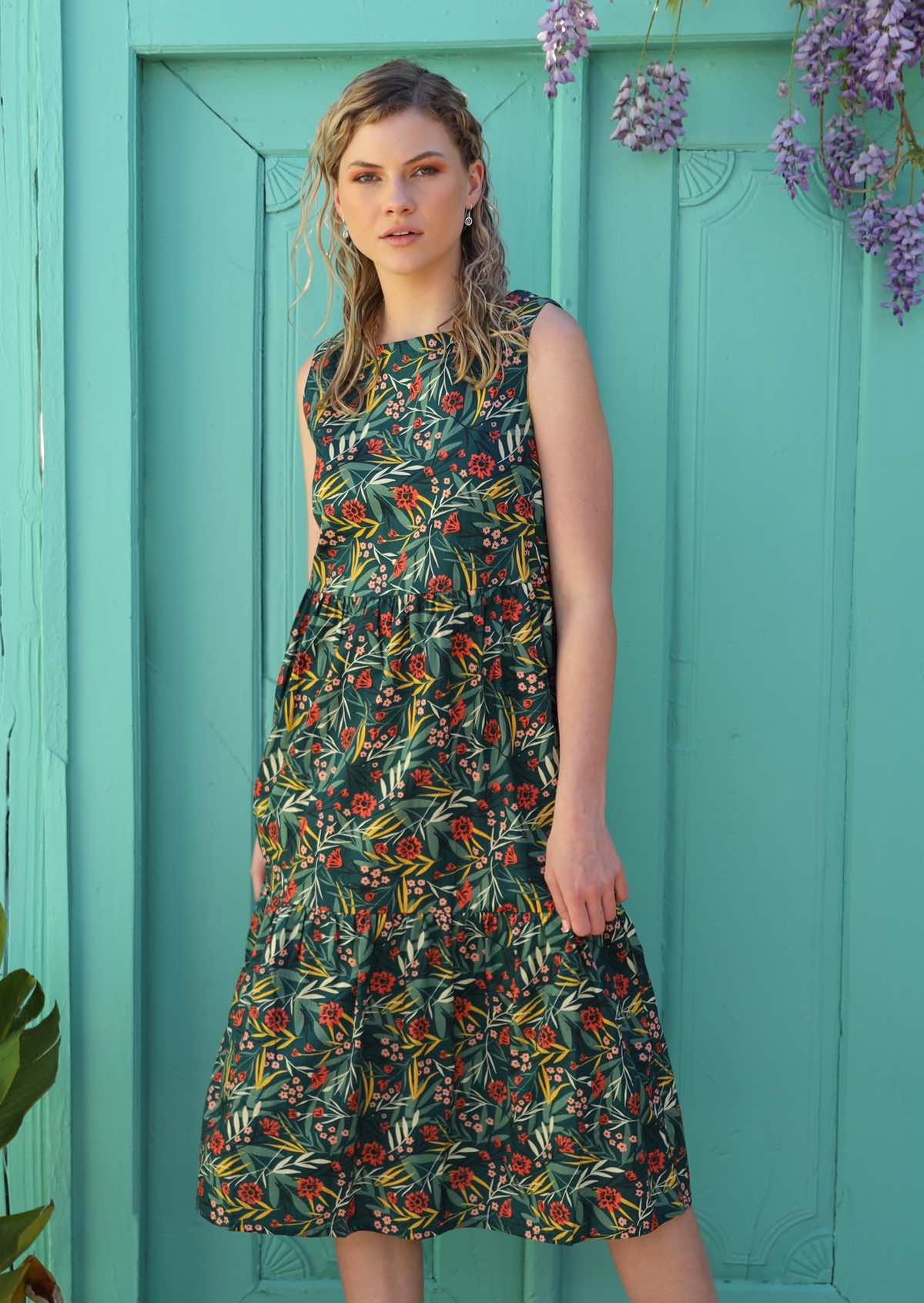Model wears green based print with a floral pattern. 