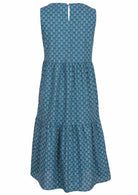 Decorative white pattern on a blue cotton dress that features a keyhole back closure. 