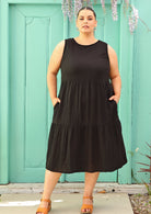Plus sized woman wearing below knee black cotton dress