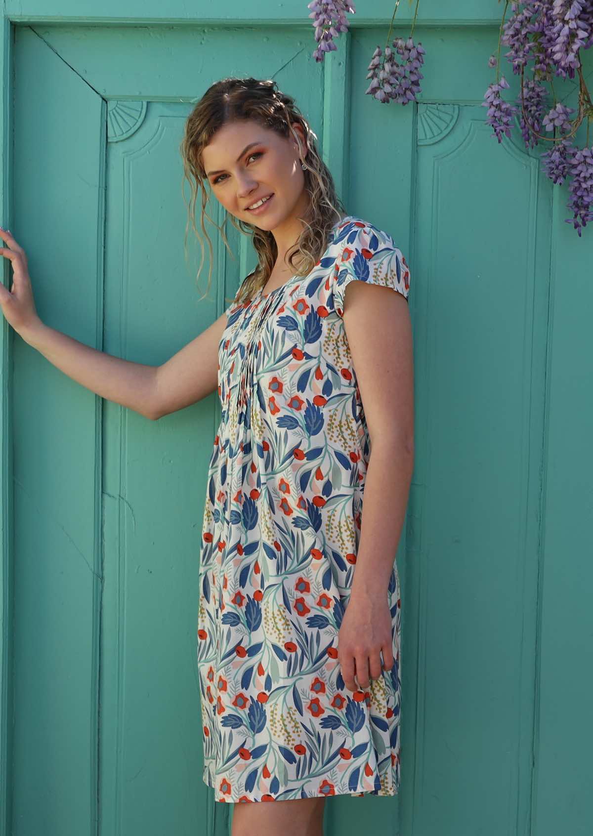 Model wears cotton floral dress with cap sleeves