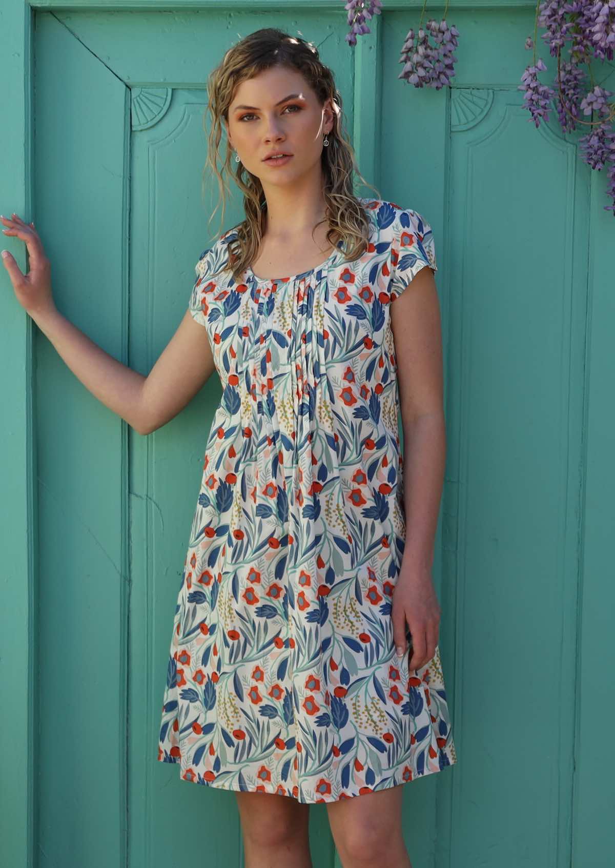 Model wears lightweight cotton dress with round neckline and cap sleeves
