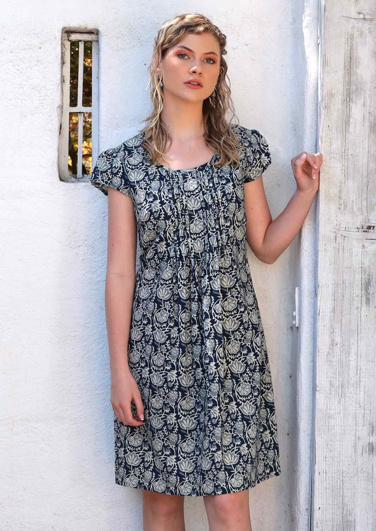 Model wears 100% cotton dress with a blue and white floral print. 