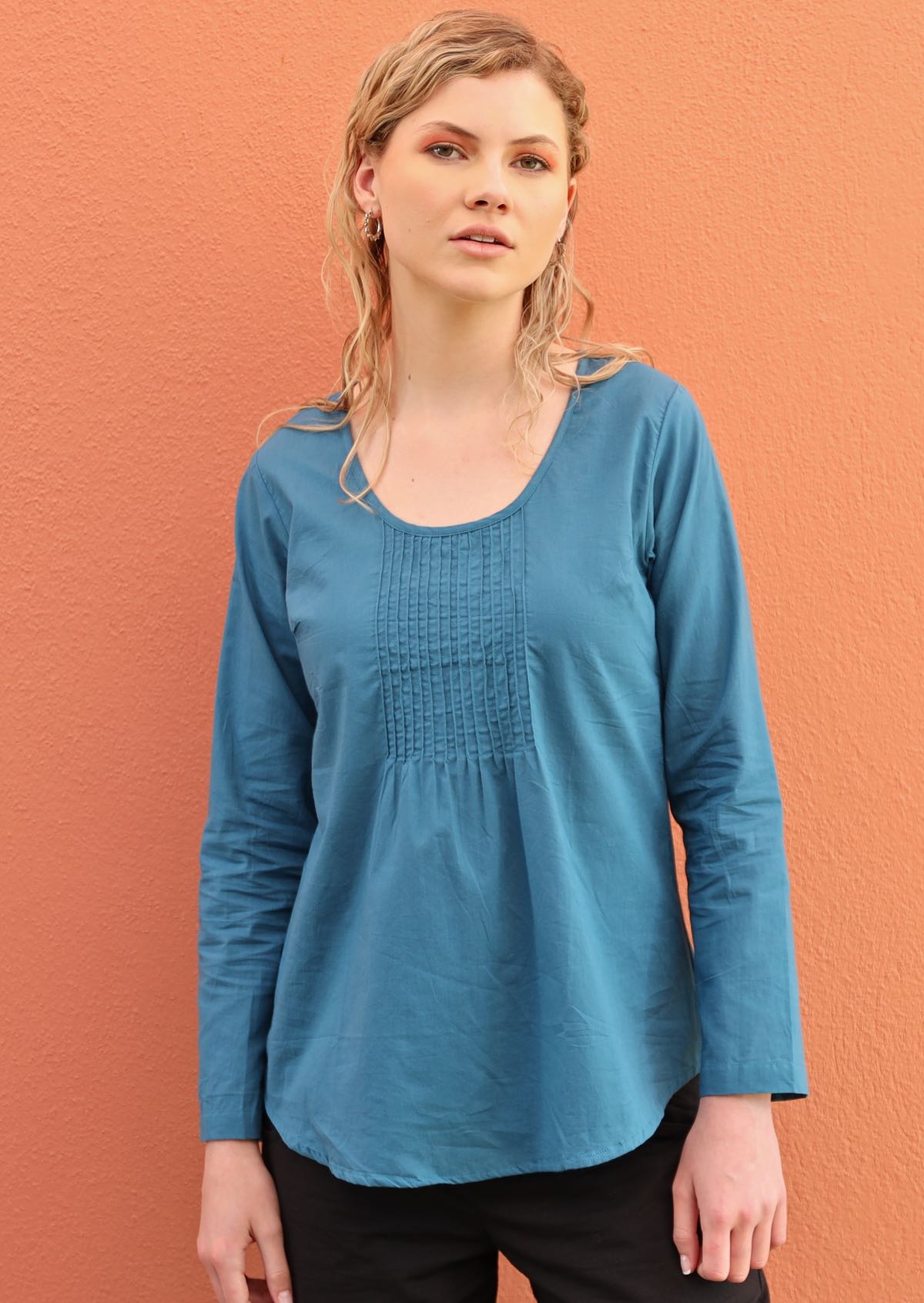 Model wears 100% cotton long sleeve top with small pleats on the bust. 